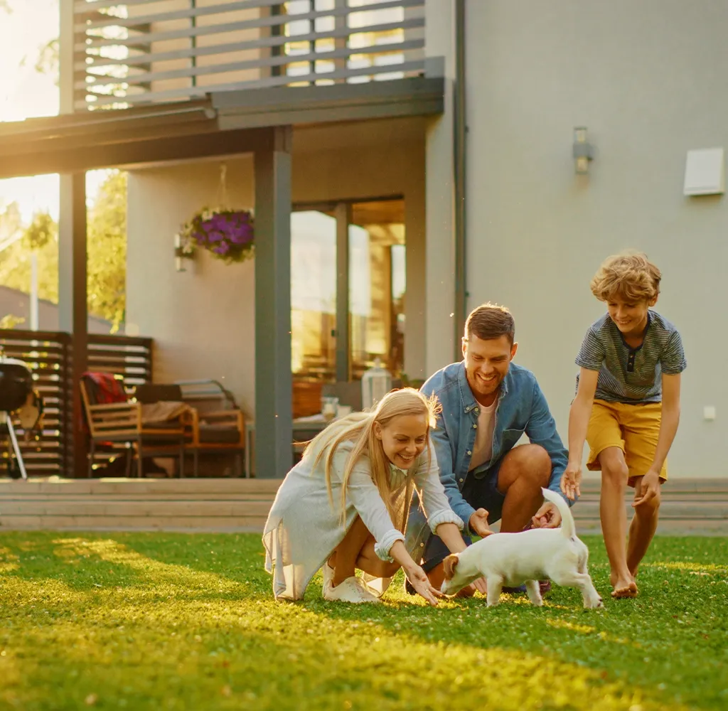 Family with dog playing outside in their new home with Artisan Finance Home Loans